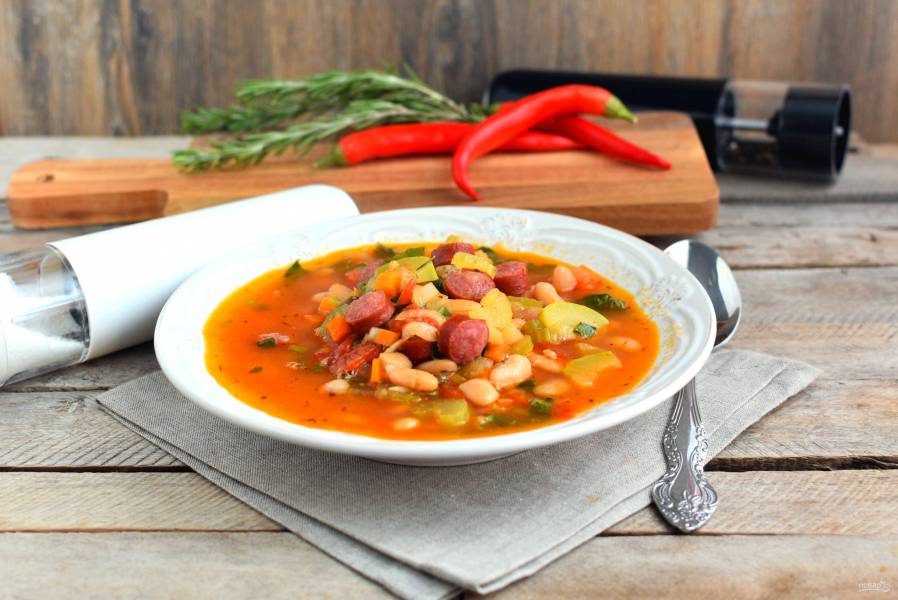 Приготовление томатного супа с охотничьими колбасками и фасолью.
