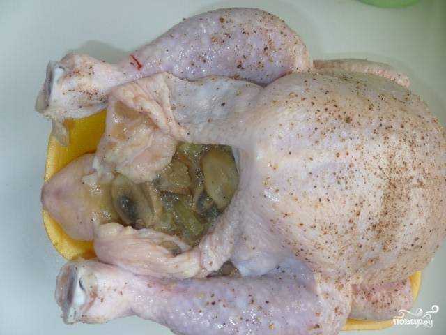 Теперь выкладываем приготовленную начинку внутрь курицы, а края скрепляем зубочистками. Можно так же связать курице ноги.