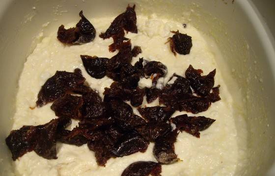 4. Домешиваем к крему размягченный чернослив, орехи и шоколад, поломанный на кусочки.