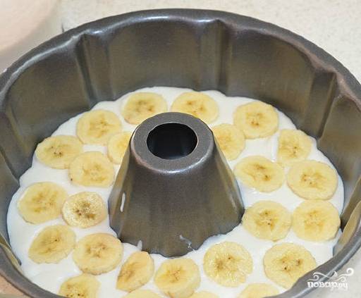Берем форму для выпечки. Наливаем в нее часть желейной творожной массы. Выкладываем сверху кружочки бананов. Следующим слоем опять наливаем желе. Так делаем несколько раз, пока не закончится масса.