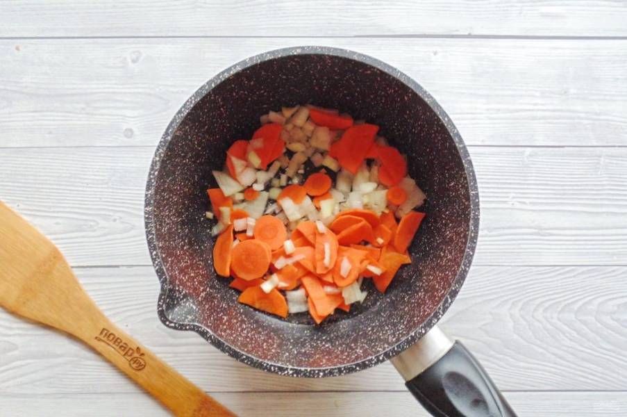 Морковь и репчатый лук очистите, помойте и нарежьте, но не очень крупно. Выложите в кастрюлю с толстым дном, сковороду или сотейник. Налейте растительное масло и тушите на среднем огне 5-6 минут, перемешивая.