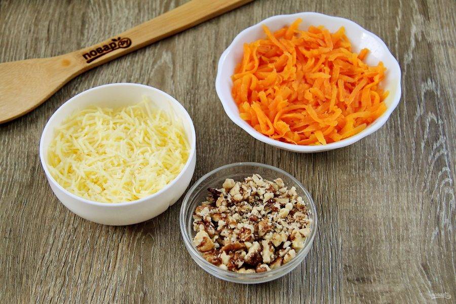 Сыр натрите на мелкой терке, морковь – на крупной. Орехи измельчите при помощи скалки.