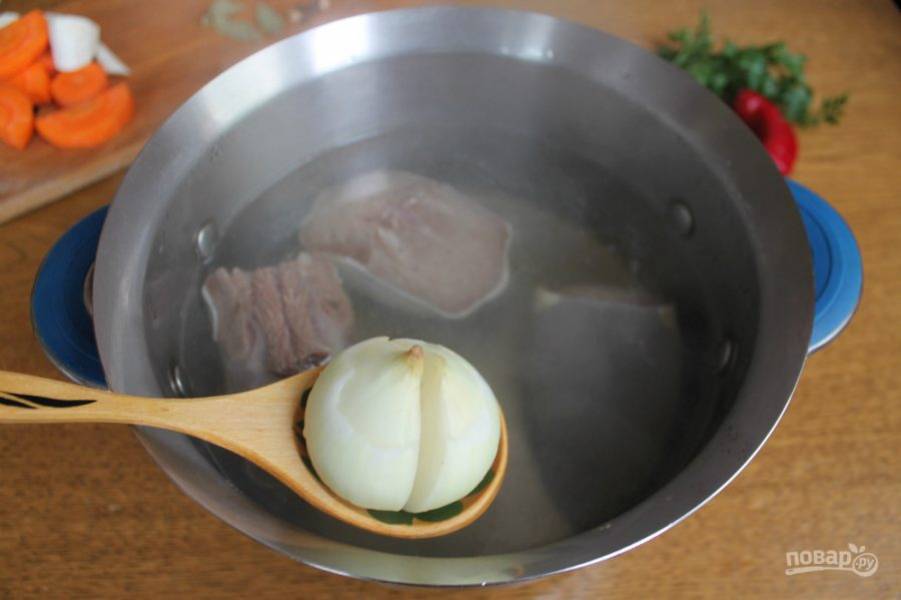 В кипящий бульон добавляем разрезанный на 2 части лук.