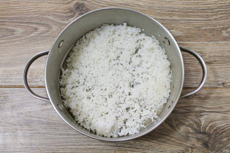 В кастрюлю налейте литр воды, посолите и доведите до кипения. Всыпьте промытый рис и варите после закипания в течение 15 минут на среднем огне. Откиньте рис на сито, промойте и дайте воде полностью стечь.