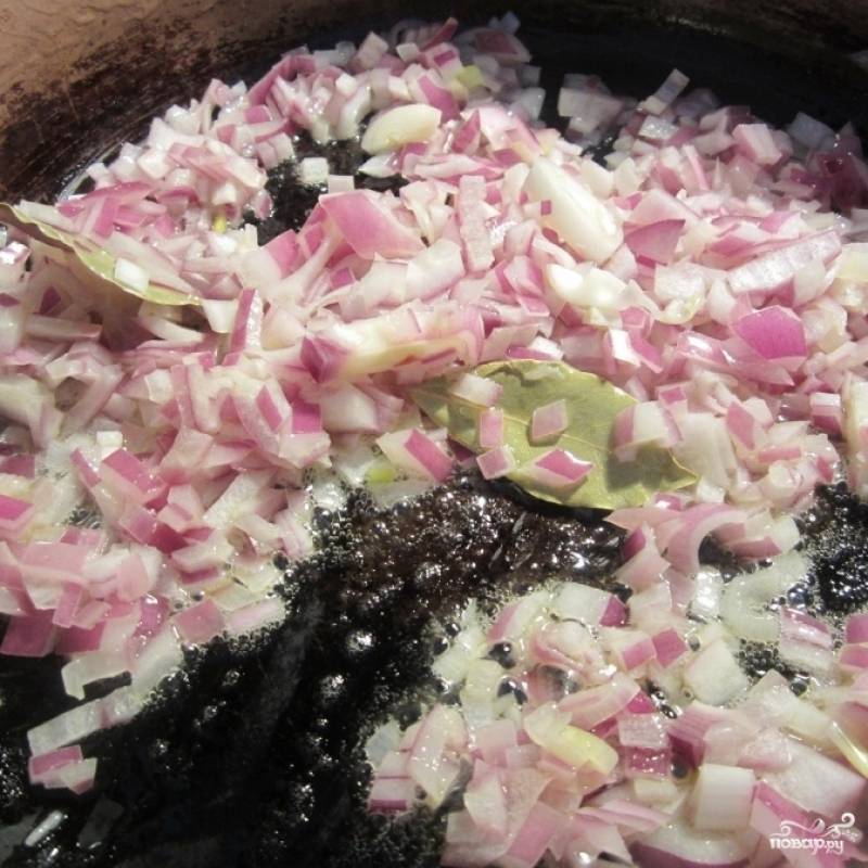 Растопите сливочное масло в большой суповой кастрюле на среднем огне. Добавьте мелко нарезанный лук и лавровый лист.