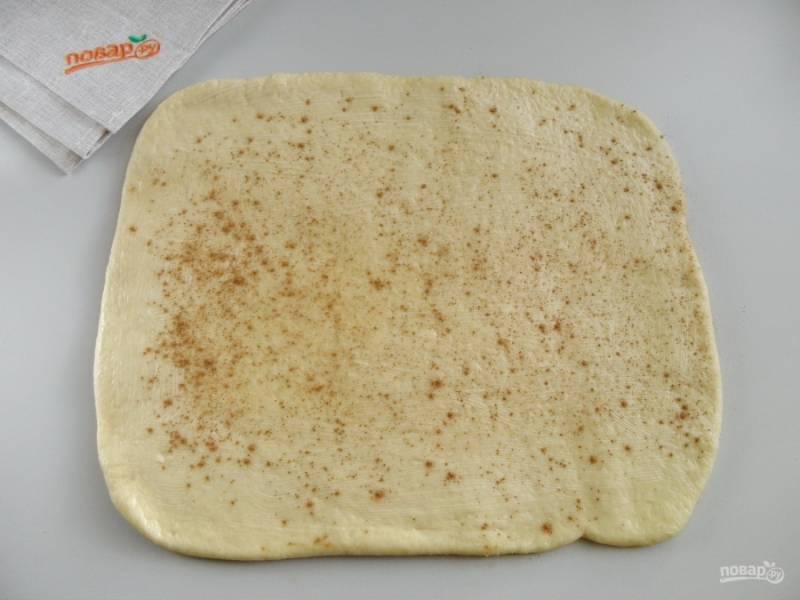 7. Раскатайте тесто в прямоугольник. Смажьте растопленным сливочным маслом. По желанию посыпьте молотой корицей или просто сахаром. 