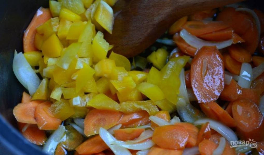 В кастрюле с толстым дном обжарьте на масле морковь с луком в течение 3-х минут. Затем добавьте нарезанный перец. Жарьте вместе ещё 5 минут.