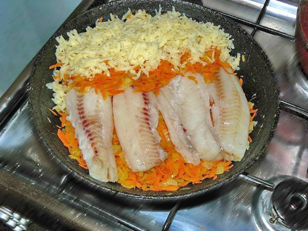 Обжариваем морковь с луком на сковороде до полуготовности. Половину овощей убираем, кладем рыбу, сверху - слой моркови, майонез и тертый сыр.