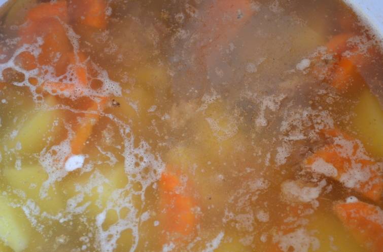 После того как пройдет час с момента закипания бульона, мы аккуратно извлекаем из него луковицу и лавровый лист (они нам больше не понадобятся). Опускаем нарезанные свежие овощи в воду, доводим ее до кипения, затем солим по вкусу. Варим суп еще 35-40 минут, а за 5 минут до готовности добавляем в него сушеную зелень.