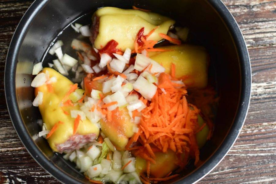 Измельчите лук, морковь и выложите их к перцу.