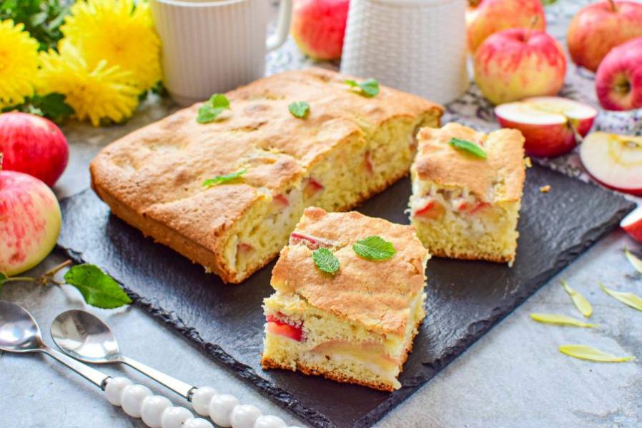 Готовую шарлотку с яблоками нарежьте на кусочки и подавайте к столу.