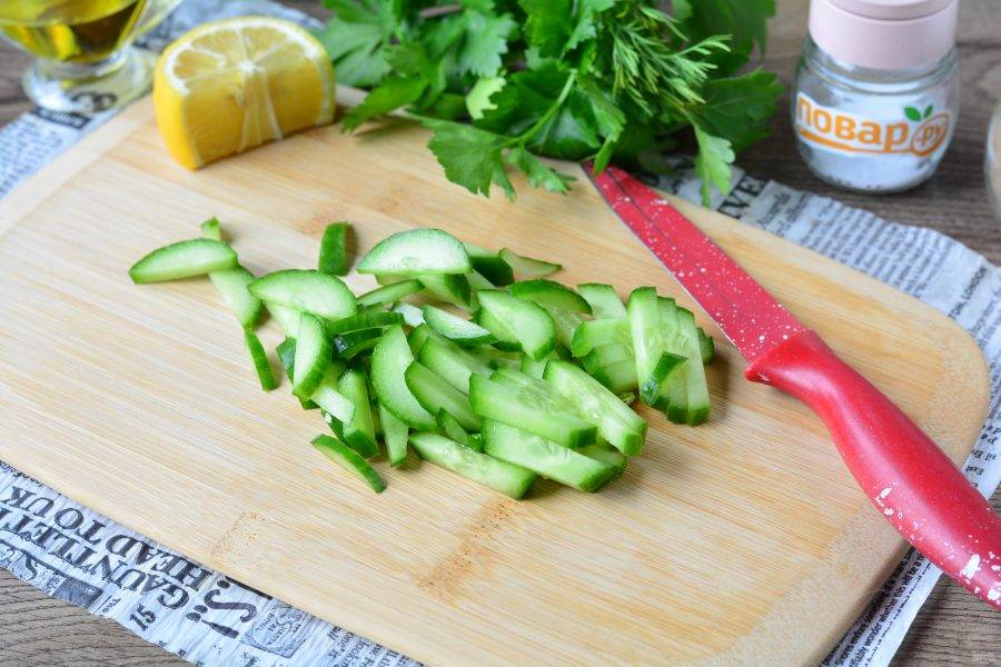 Нарежьте средними полосками свежие огурцы.