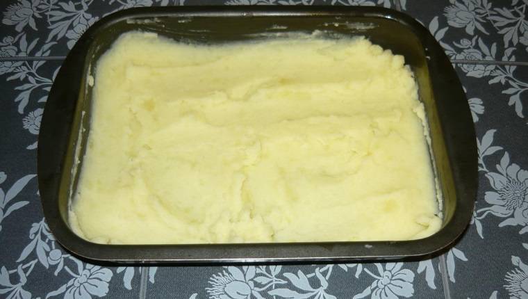 1.	Обычным способом приготовьте картофельное пюре. Форму для запекания смажьте маслом, выложите в нее ½ от всего количества пюре ровным слоем.