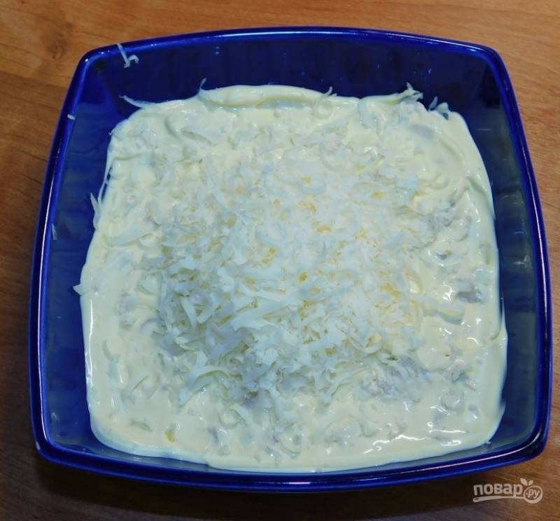 Вторым слоем натрите сыр на мелкой терке. Затем снова смажьте майонезом.