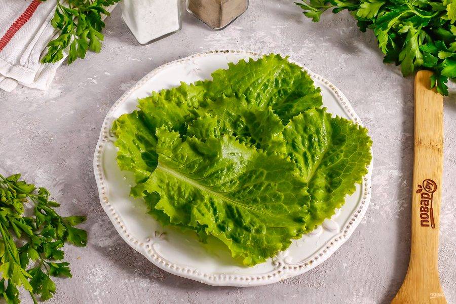 Промойте листья салата, срежьте стебли и стряхните с них лишнюю влагу. Выложите на тарелку.