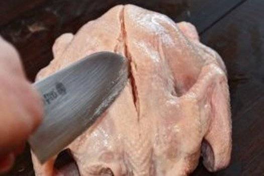 1. Самое ответственное в приготовлении данного блюда - это подготовка курицы. Для начала следует  по середине спины, после чего надрезать кожу и немного зацепить само мясо.