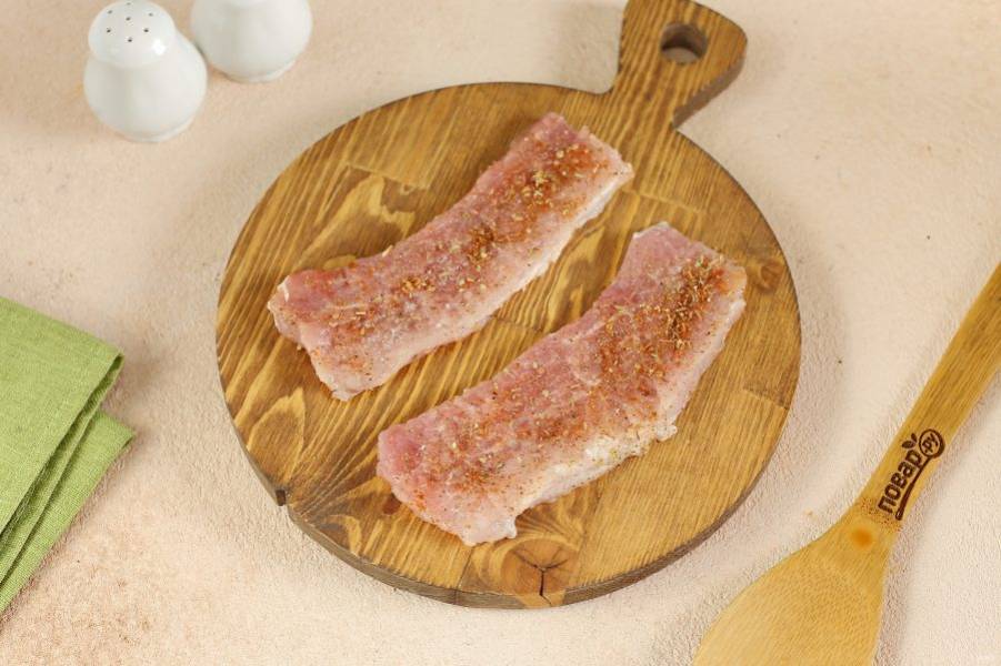 Свинину нарежьте на порционные кусочки, слегка отбейте с двух сторон, натрите солью и специями.