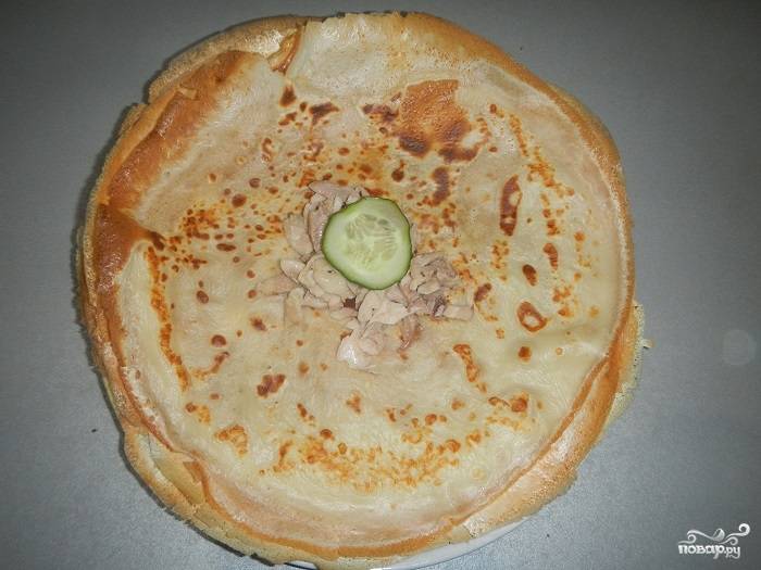 3. Отвариваем куриное мясо, остужаем его и нарезаем кусочками. Огурец моем и нарезаем тонкими кружочками. На каждый блин выкладываем чайную ложку кетчупа, затем немного мяса и на верх кладем огурчик.