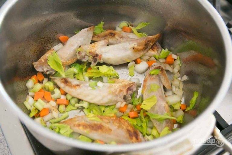 4.	Нарежьте кубиками морковь, лук, сельдерей и выложите овощи в кастрюлю к крыльям, обжаривайте несколько минут.