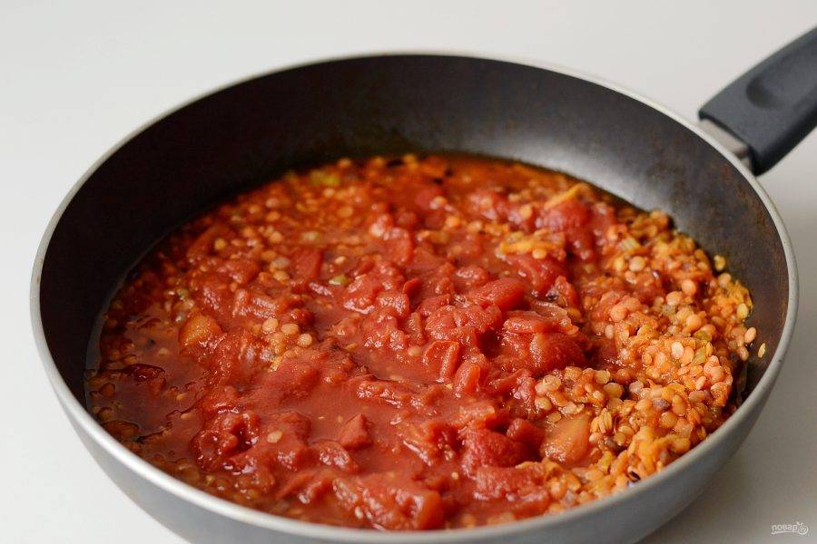 Добавьте томаты в собственном соку и немного воды (при необходимости), чтобы она покрывала чечевицу. Посолите, поперчите и приправьте копченой паприкой. Накройте крышкой и тушите на среднем огне 20 минут.
