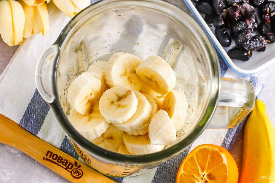 Банан очистите от кожуры и нарежьте мякоть кружочками, высыпьте в емкость блендера или кухонного комбайна. Влейте холодную воду без газа и лимонный сок.