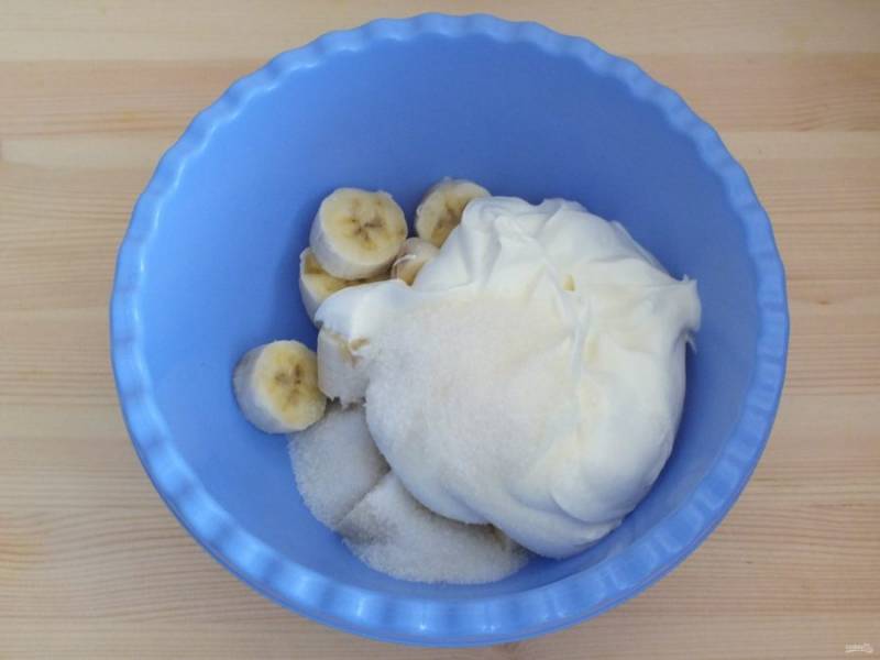 В глубокой таре пробейте погружным блендером сметану, сахар, ванилин, нарезанные бананы.