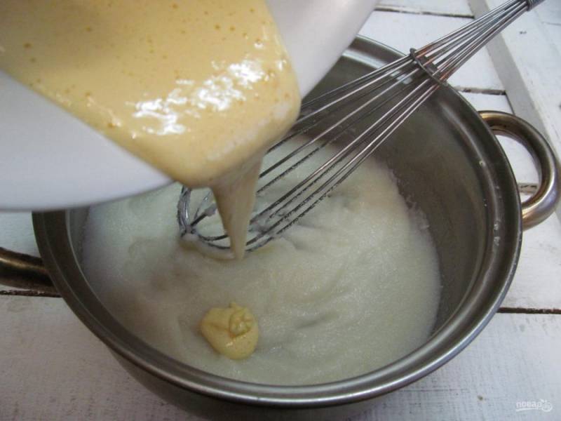 В кашу введите желтки с сахаром и перемешивайте венчиком или лопаткой. Кастрюля при этом стоит на плите - огонь самый малый. Перемешивая, готовьте 30 секунд, до кипения доводить не нужно. 