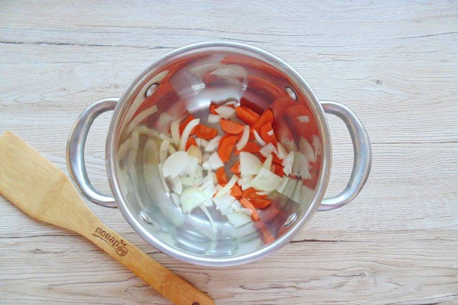 Морковь и лук очистите, помойте. Нарежьте лук полукольцами, а морковь произвольно, но мелко. Выложите в кастрюлю с толстым дном.