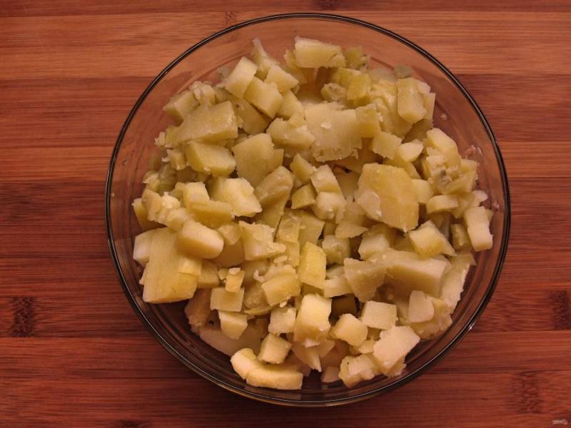 Картофель нарежьте некрупно и добавьте в салатницу.
