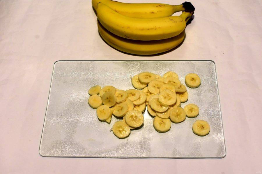 Банан очистите и нарежьте тонкими кружочками. На один слой торта идет примерно один средний банан.