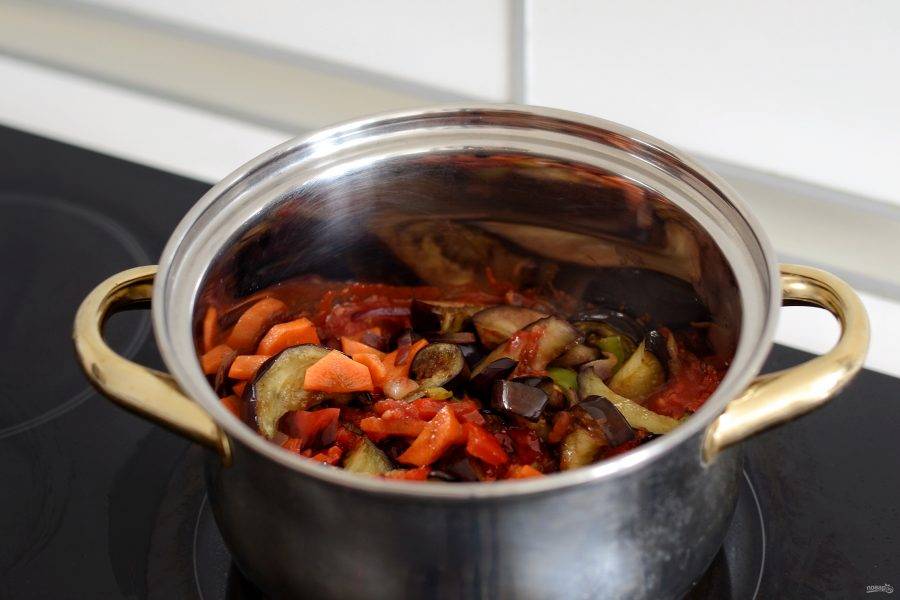 Добавьте обжаренные овощи и специи. Тушите под крышкой на медленном огне, пока не испарится лишняя жидкость. 
