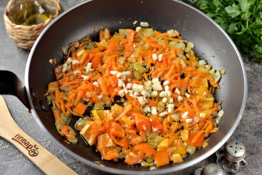 Добавьте измельченную морковь и болгарский перчик, тушите на умеренном огне минут 10. Когда овощи станут полностью мягкими, добавьте чеснок и подержите еще около минуты. 