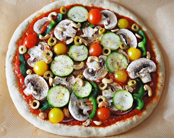 Смажьте соусом, выложите нарезанные овощи и грибы, посыпьте специями.
Запекаем вегетарианскую пиццу с грибами минут 20 при 230 С. 
Приятного аппетита!