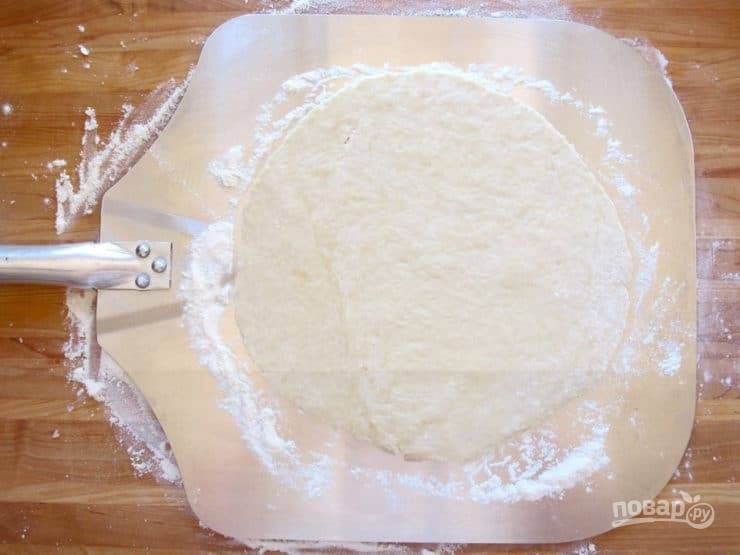 5. После этого раскатайте тесто в тонкий круг или круги. Выложите его на специальную лопатку, чтобы удобно установить на гриль.