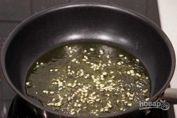 За 3 минуты до готовности пасты нагрейте оливковое масло в сковороде с антипригарным покрытием, добавьте мелко нарезанный чеснок.