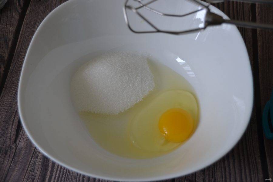 Взбейте миксером яйцо комнатной температуры и 100 грамм сахара.