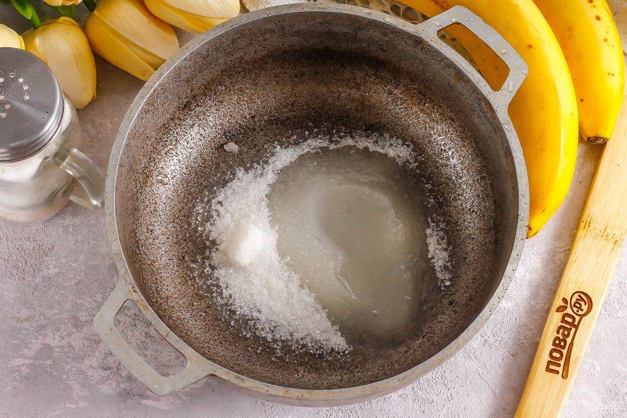 Сахар высыпьте в казан и влейте теплую воду и лимонный сок. Прогрейте на плите до пузырей.