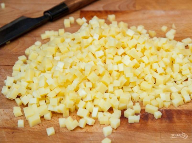 5.	Твердый сыр нарежьте ножом на мелкие квадратики, предварительно отправьте его в холодильник, так гораздо удобнее.