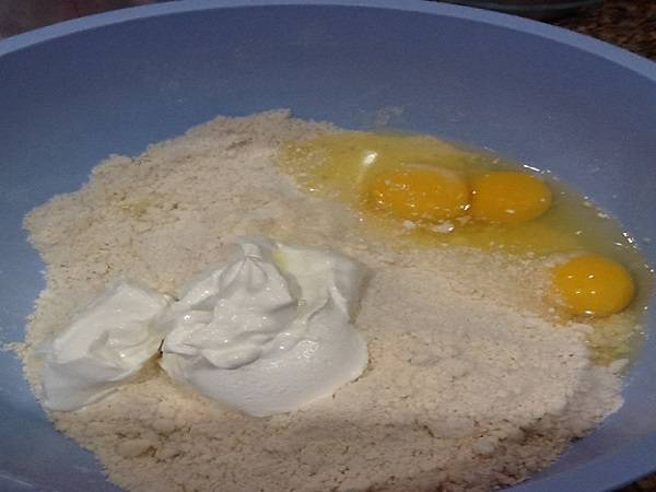 3. Добавить щепотку соли, сметану и вбить яйца. Продолжить руками замешивать тесто. 