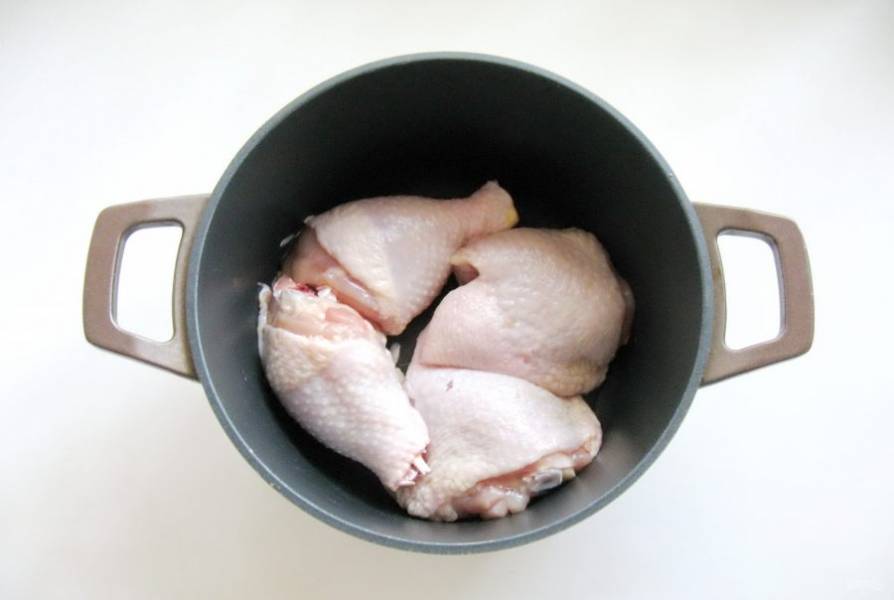 Любые мясистые части курицы помойте и выложите в кастрюлю с толстым дном.