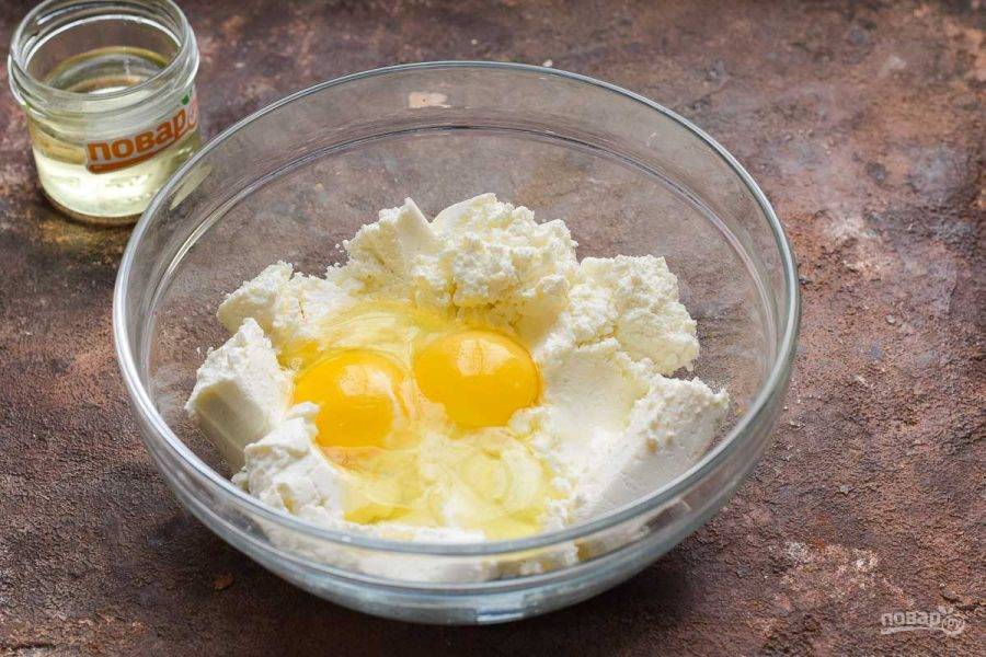 Творог перетрите и переложите в миску, добавьте к творогу куриные яйца.