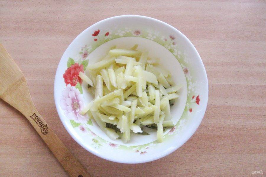 Картофель сварите в кожуре, охладите и очистите. Нарежьте соломкой и добавьте в салат.