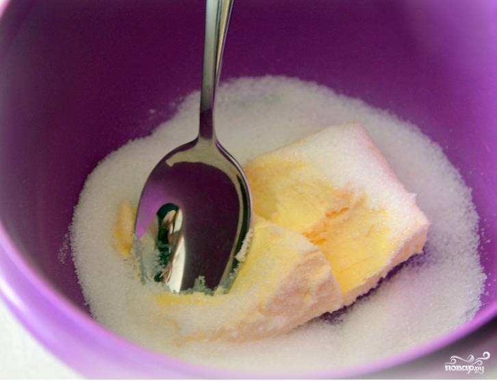 Достаем пачку масла. Кладем в миску и оставляем в тепле. Когда оно размягчится, насыпаем сахар. Растираем масло с сахаром.