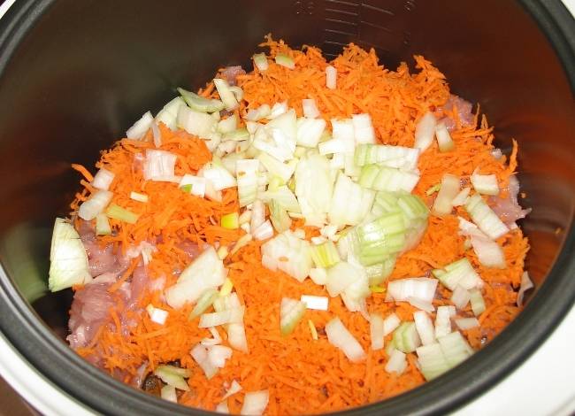 Морковь трем на крупной терке, репчатый лук нарезаем кубиками, выкладываем овощи в мультиварку. 