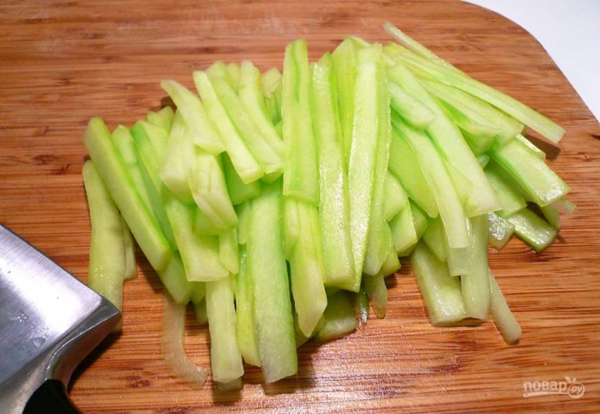 Все овощи вымойте. С огурца снимите шкурку острым ножом или специальной чистилкой. Нарежьте его соломкой. Помидоры нарежьте кружочками, черри можно просто разрезать на две половинки. 