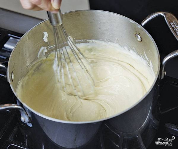 5. Последний подготовительный этап — это соус. Для его приготовления в сотейнике доведите до кипения молоко. Отдельно на сковороде растопите сливочное масло. Всыпьте муку и тщательно перемешайте, чтобы не было комочков. Когда мука станет золотистой, переложите ее в молоко. Добавьте соль, перец, мускатный орех и снимите с огня. Остудите немного, а после добавьте взбитые яйца и тертый сыр. Продолжайте взбивать, пока соус не станет полностью однородным. 