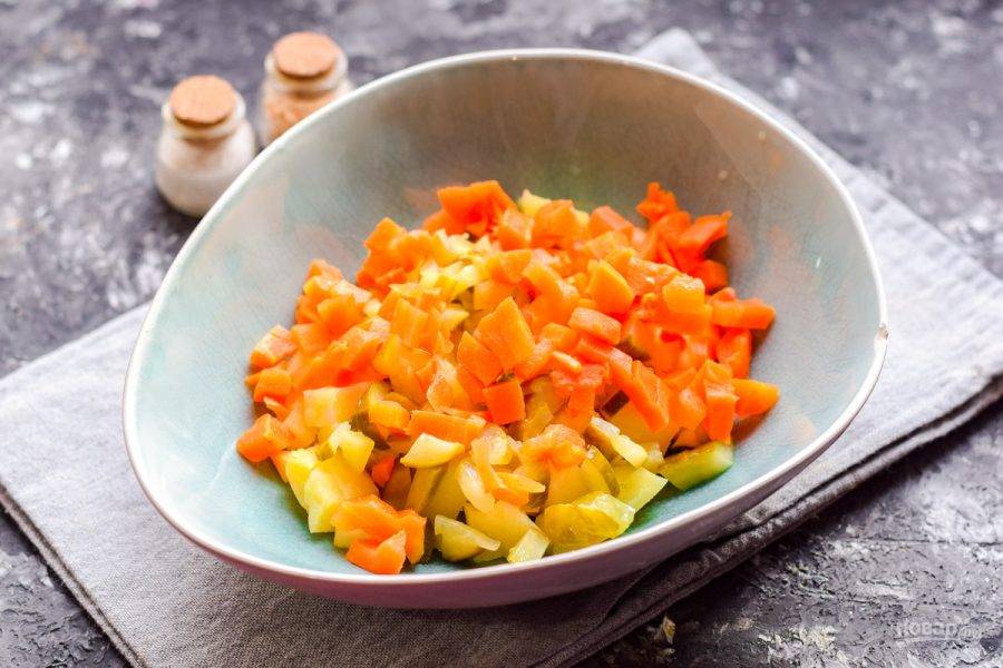 Следом очистите морковь, нарежьте средними кубиками и добавьте в салат.