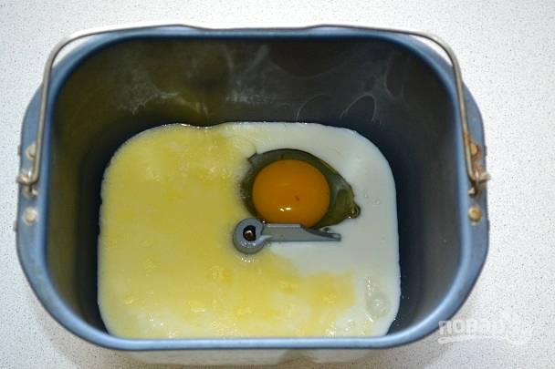 Для приготовления теста в хлебопечке на дно ведерка отправьте жидкие ингредиенты - молоко, растопленное сливочное масло, яйцо.