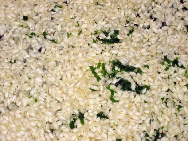 Добавляем промытый рис, жарим вместе 4-5 минут, постоянно помешивая.