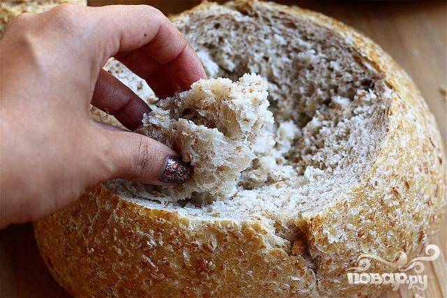 6. Вырезать круг в верхней части пшеничного хлеба. Удалить мякоть в центре, формируя миску. 